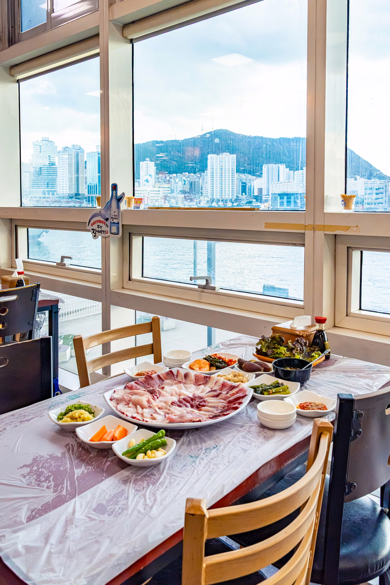 위층 식당 창가에 차린 회 한 상. 창밖은 남항과 영도다