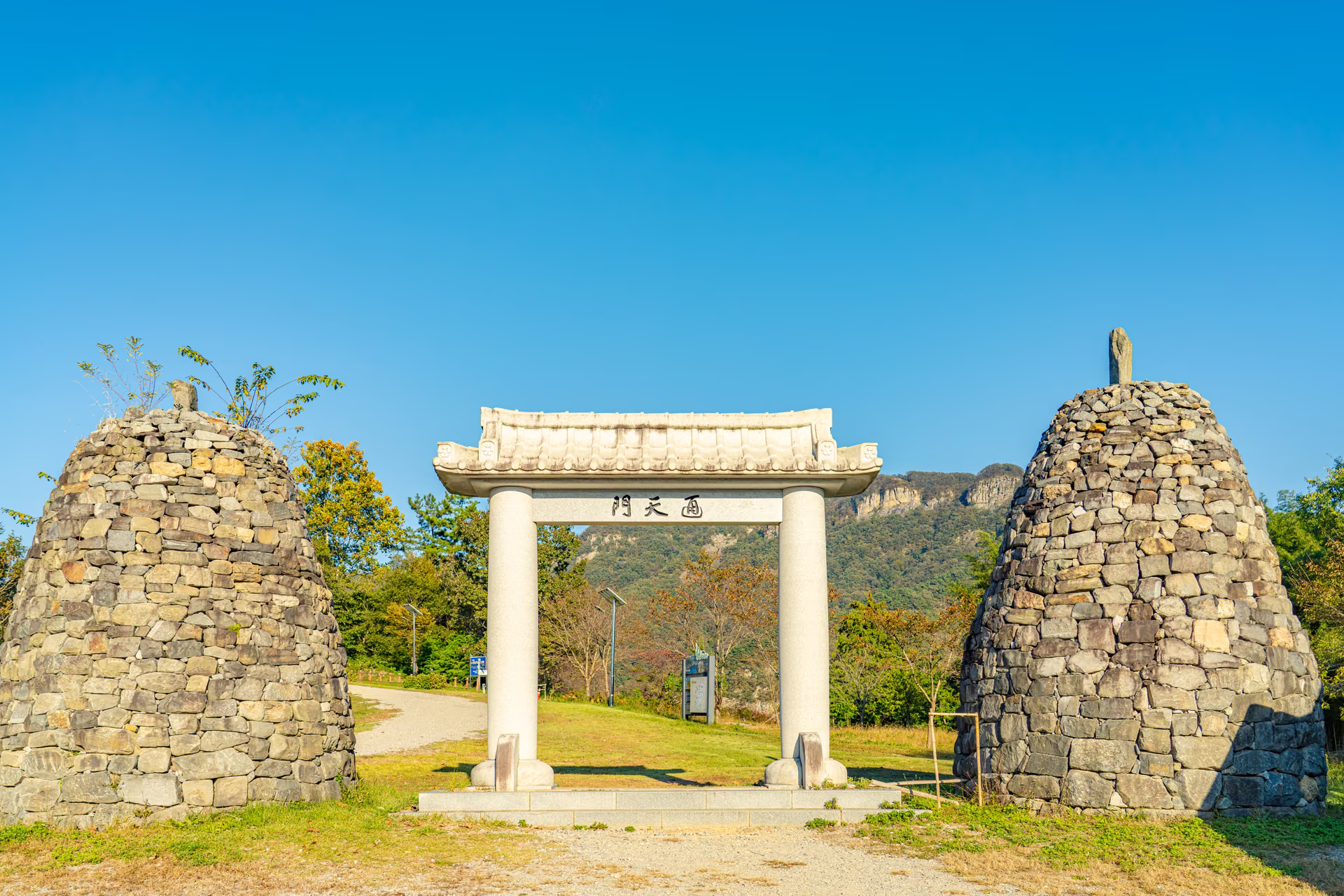 ‘通天門’ 현판을 단 돌기둥 문과 양옆의 원뿔꼴 돌탑. 뒤로 옹성산 바위 능선이 보인다