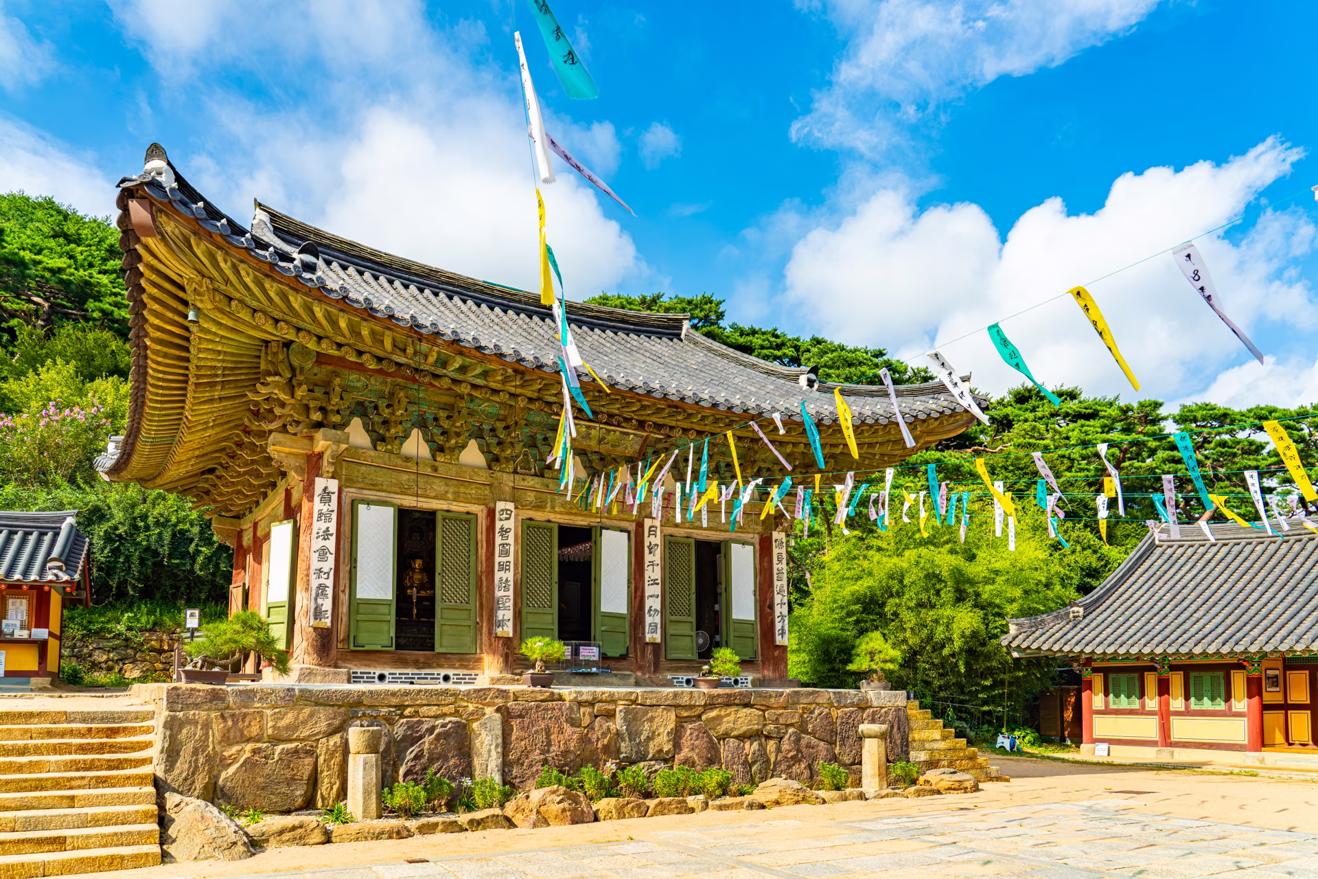 오색 줄이 걸린 마당 너머 돌 기단 위의 전등사 대웅보전