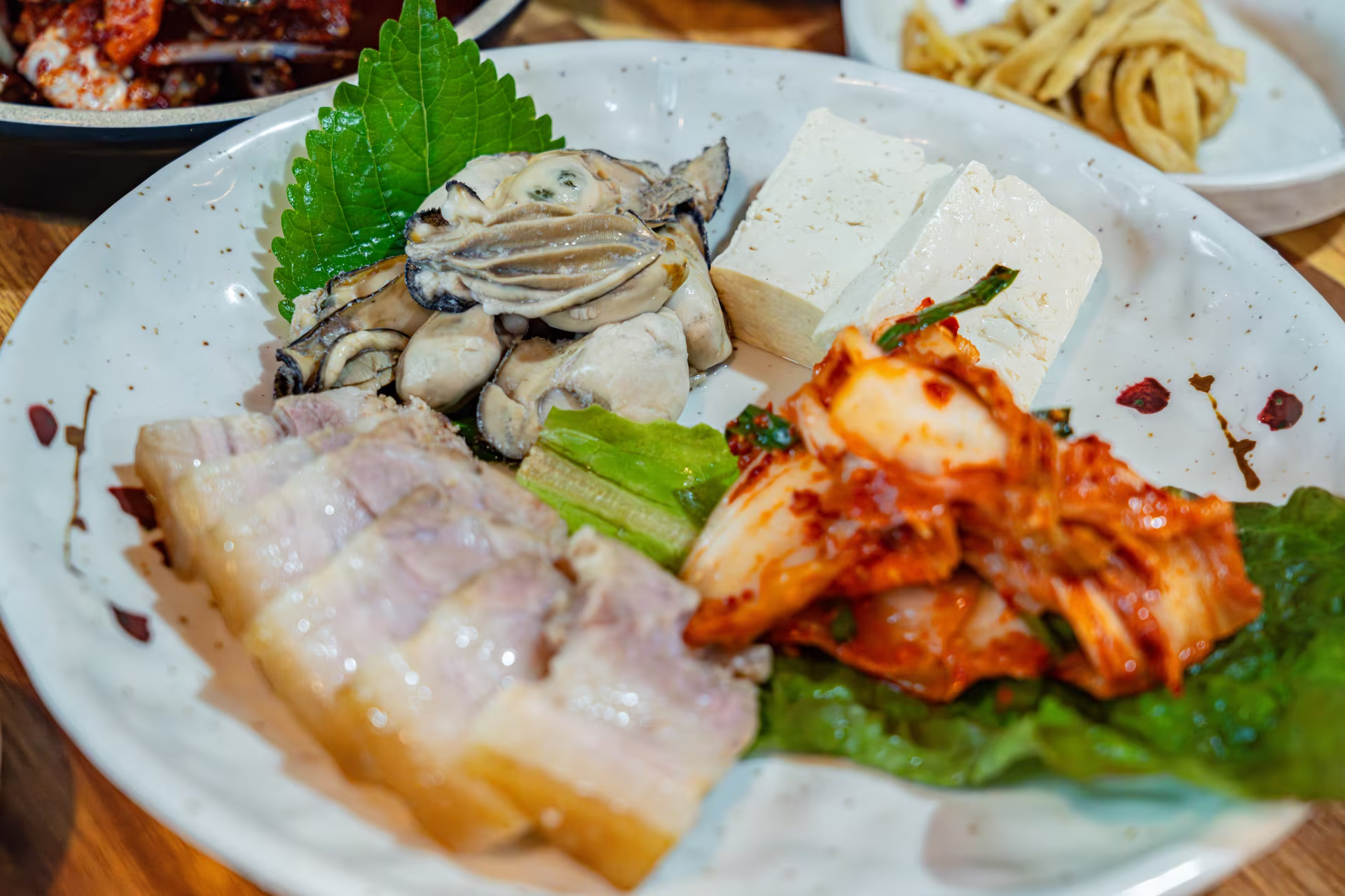 돼지고기 수육과 김치, 통영 생굴을 한 접시에 담아 낸 굴보쌈