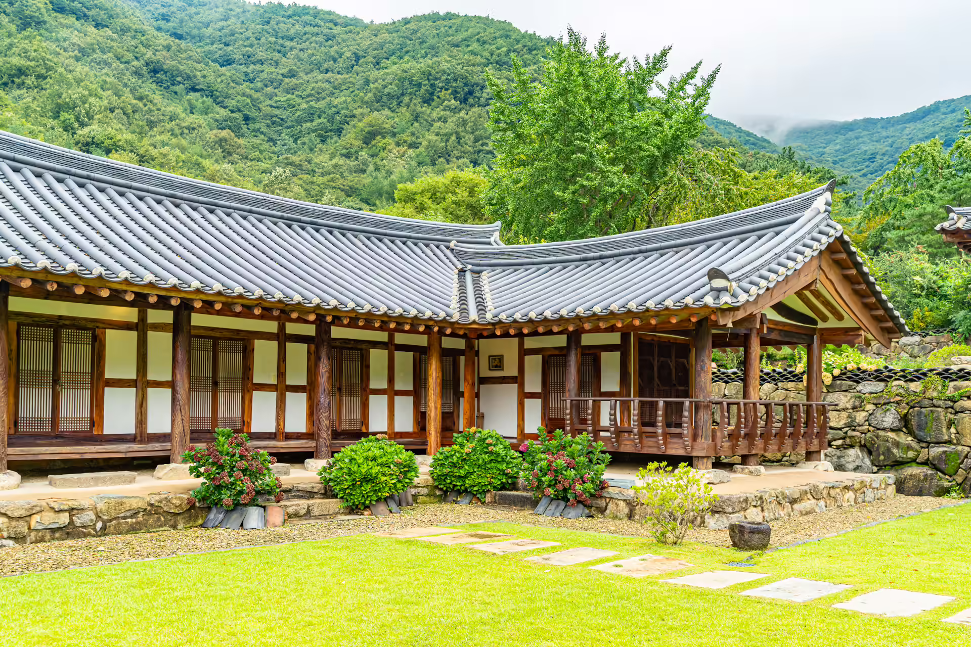 잔디 마당 위에 선 소양고택의 긴 한옥과 나무 툇마루