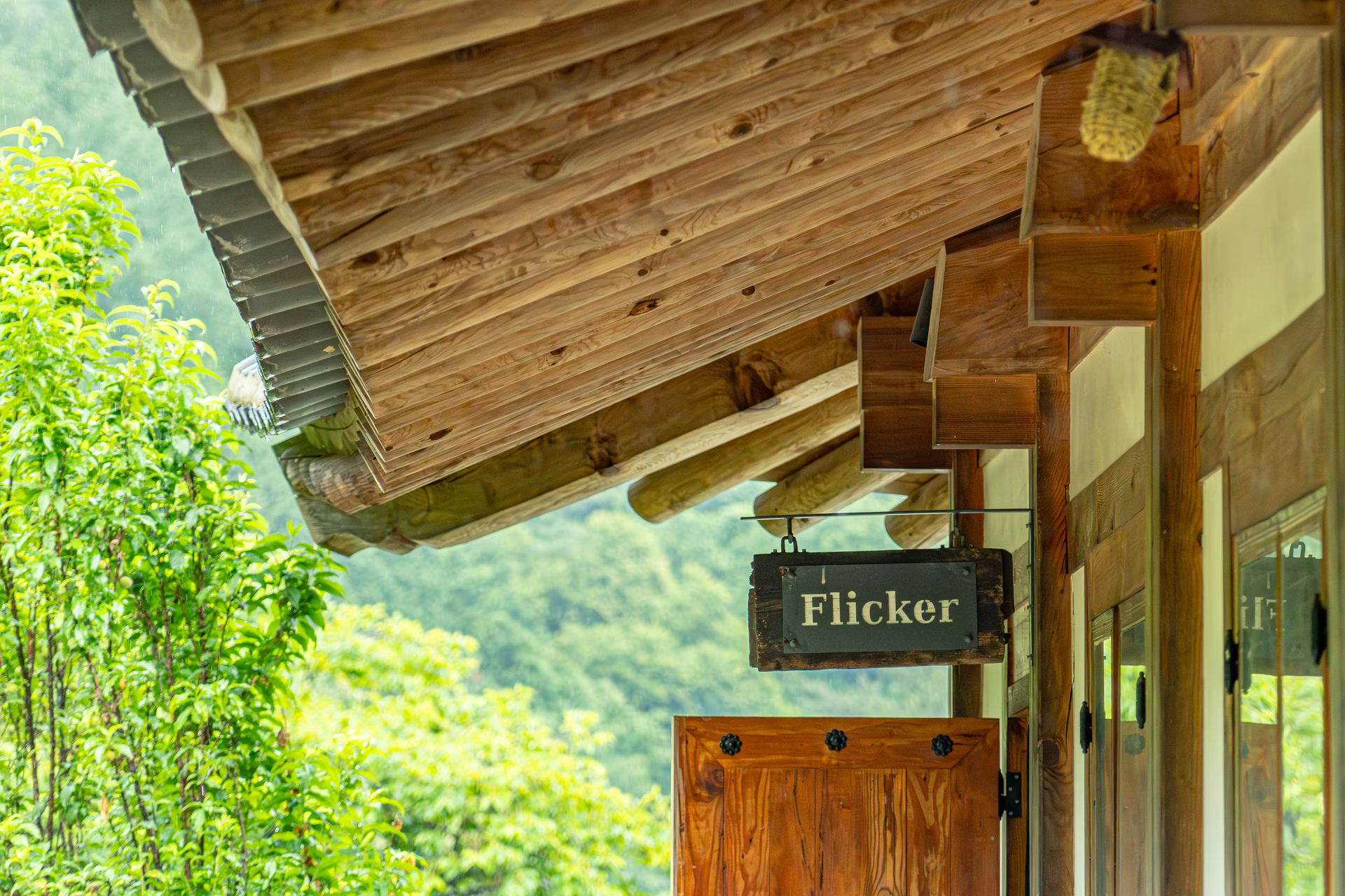 한옥 서까래와 나무 문 위에 걸린 플리커책방(Flicker) 간판